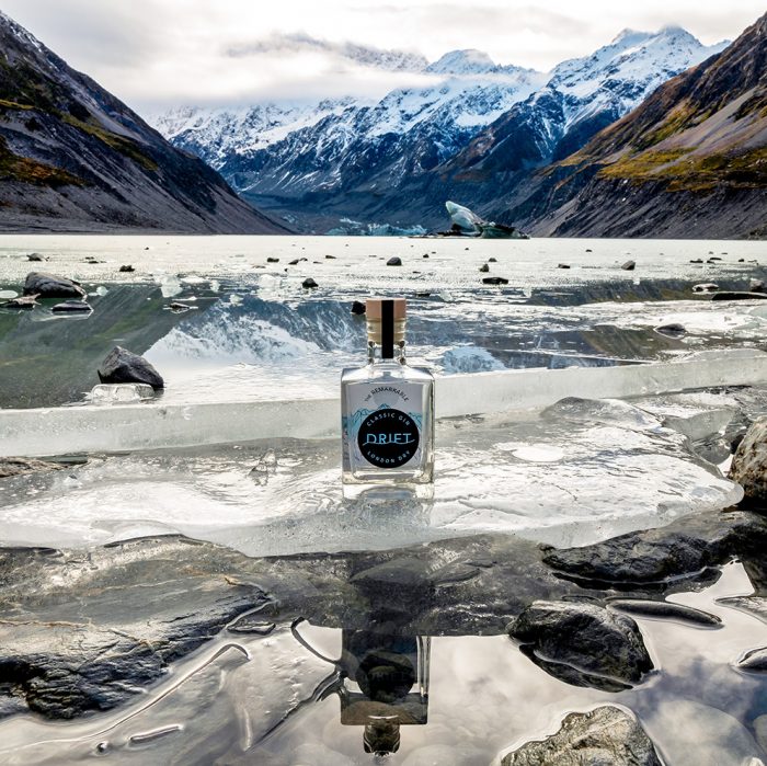 The Remarkables London Dry bottle sitting on ice at a mountian range